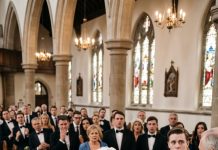 “Whatever happens next, don’t react,” my wife, a forensic toxicologist, whispered, tightly squeezing my arm at our daughter’s wedding. My heart raced as she walked straight down the aisle and lifted the collar of our daughter’s bridal gown. What she pulled free instantly left all 170 guests completely speechless. Our daughter wasn’t just nervous—she was being silently poisoned, and the culprit was standing right at the altar…